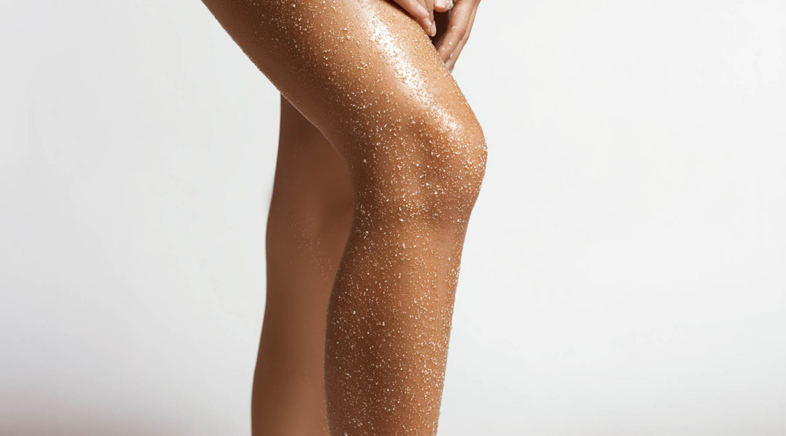 brown-sugar-scrub-womans-legs-tan-background-gray