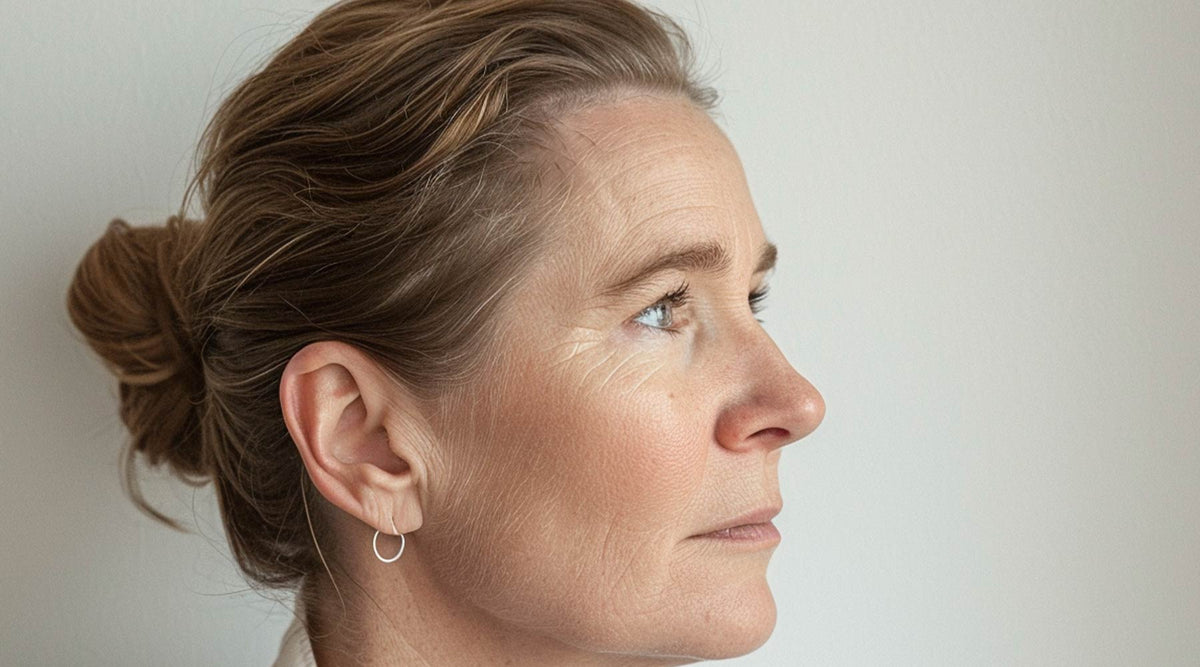 Side profile of a woman with brown hair pulled back in a bun