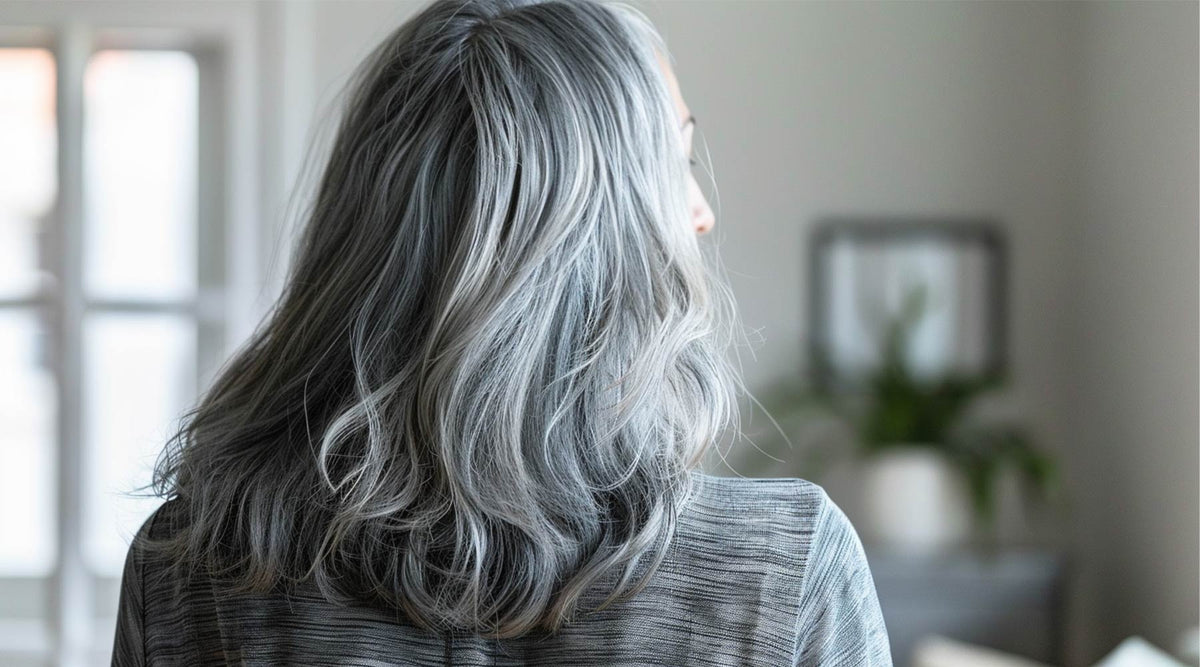Back view of a woman with long, wavy gray hair