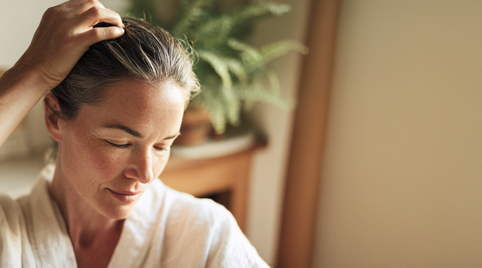 Woman touching her scalp with her fingertips