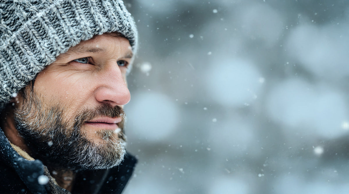 Bearded man in a knit beanie outdoors in the snow
