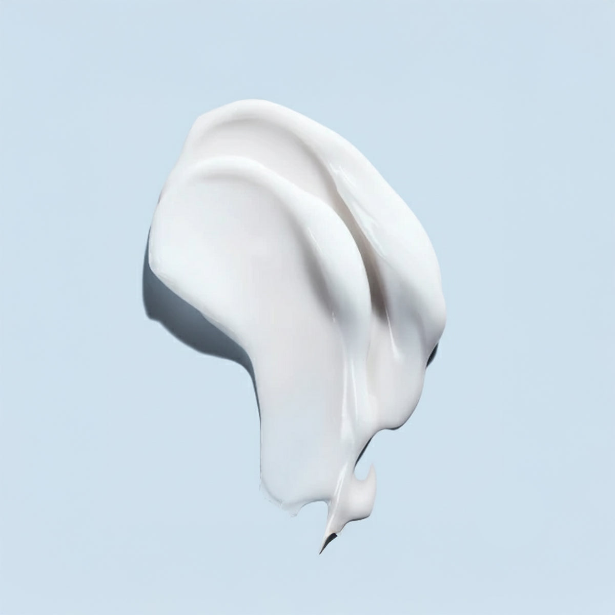 White cream or paint swatch on a light blue background