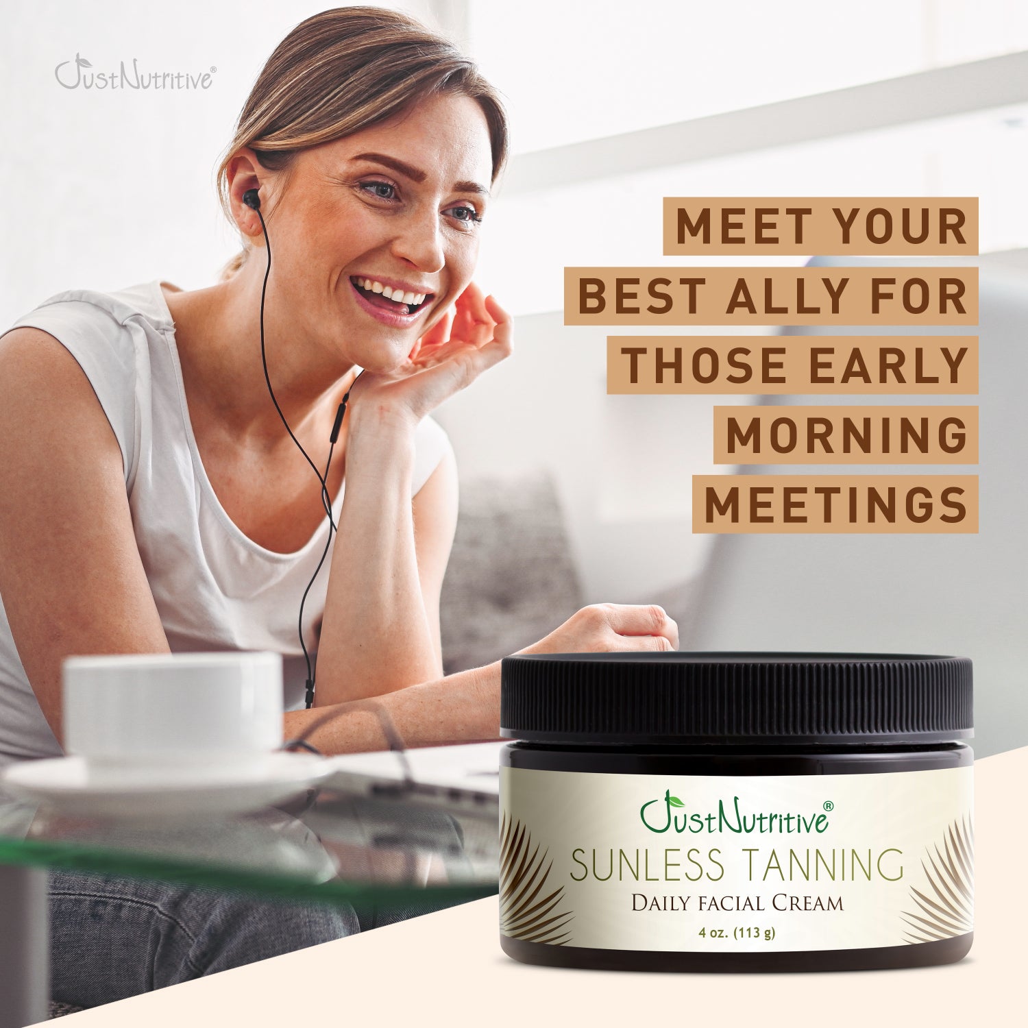Woman with a smile, sitting at a desk with a jar of Just Nutritive Sunless Tanning Daily Facial Cream.