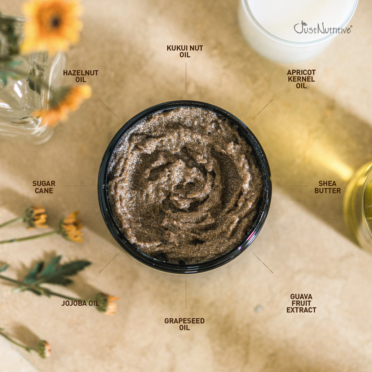 Top-down view of a bowl of brown sugar scrub with labeled ingredients on a beige surface.