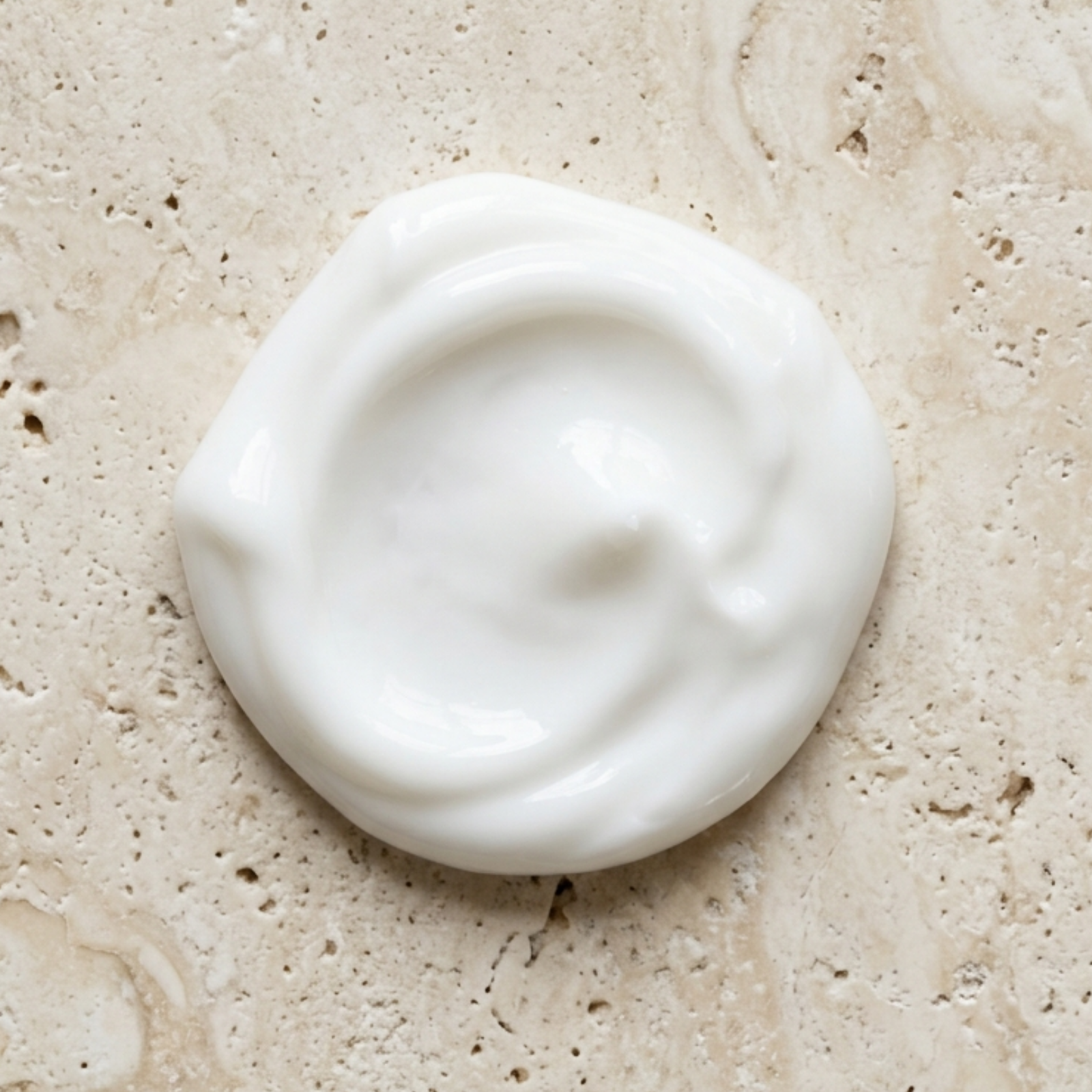 White cream or soap bar on a beige stone surface